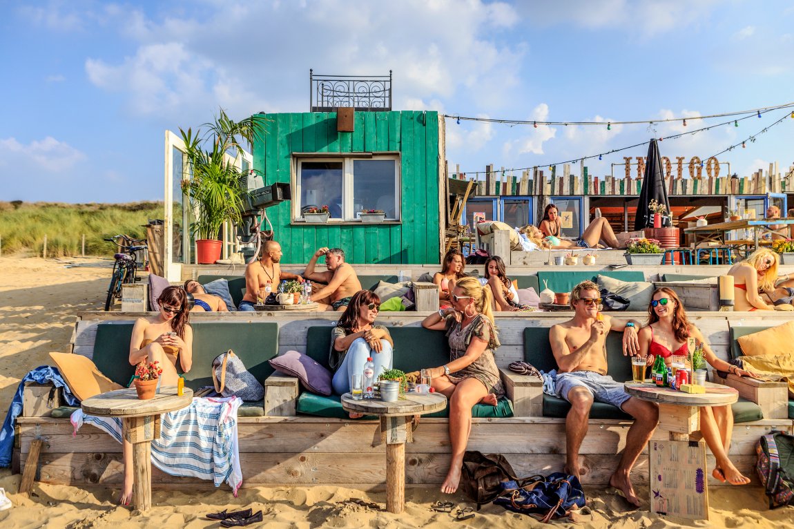 Mensen ontspannen bij Beachclub 'Indigo in Scheveningen
