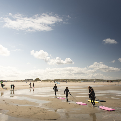 Kinderen lopen uit zee met hun bodyboards op het strand van Hoek van Holland