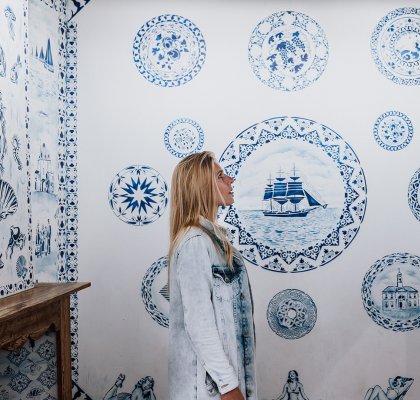 Vrouw bekijkt Delftse Blauwe wand in Zuiderzeemuseum