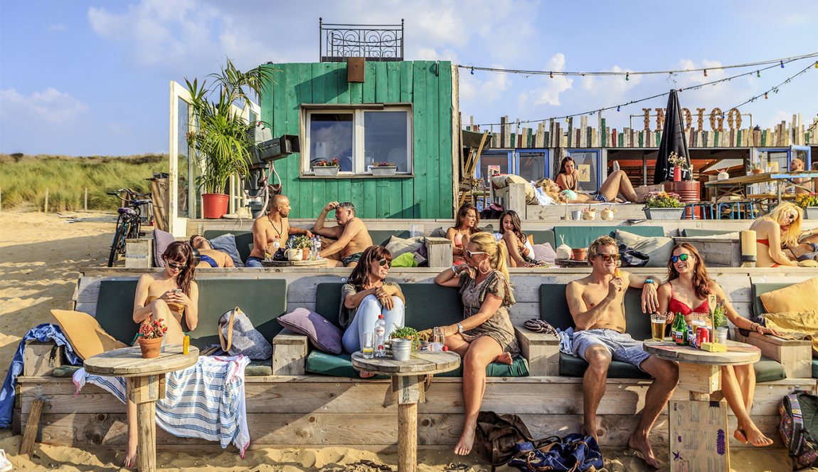 Mensen ontspannen bij Beachclub 'Indigo' in Scheveningen