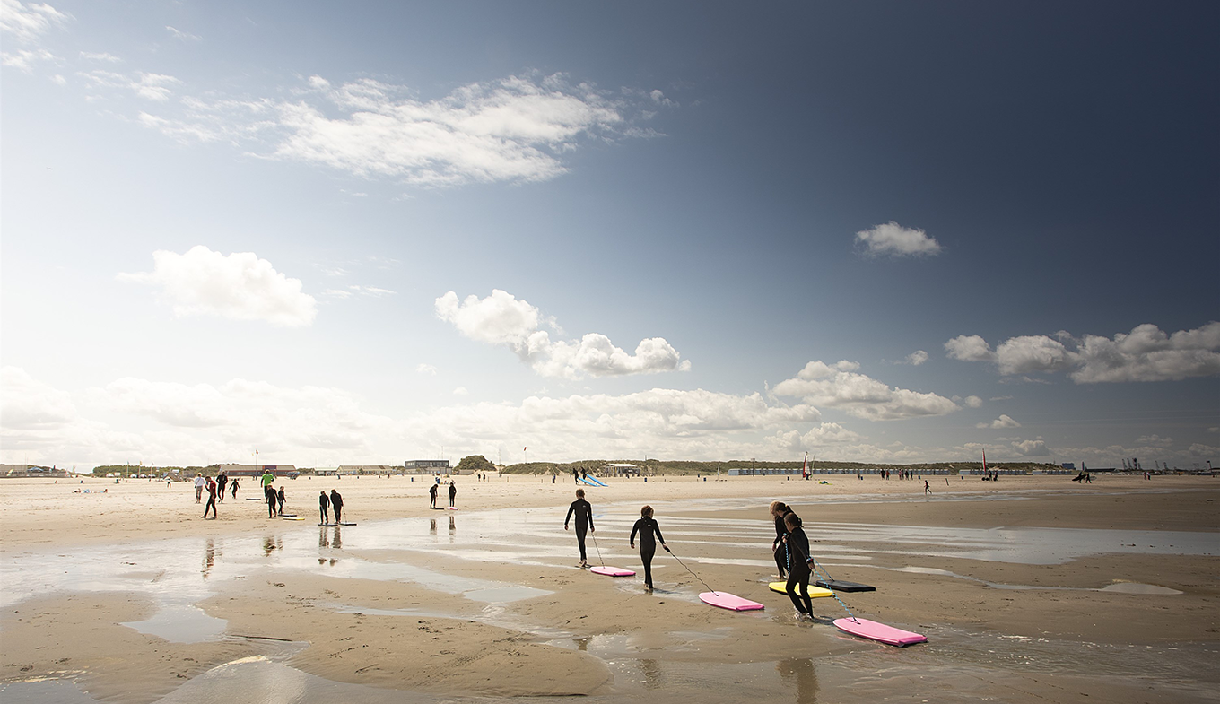 Kinderen lopen uit zee met hun bodyboards op het strand van Hoek van Holland Kinderen lopen uit zee met hun bodyboards op het strand van Hoek van Holland