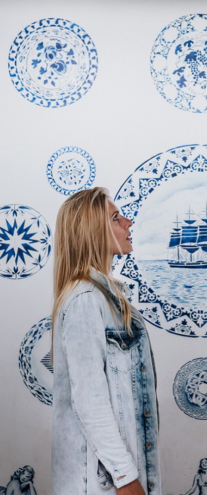 Vrouw bekijkt Delftse Blauwe wand in Zuiderzeemuseum