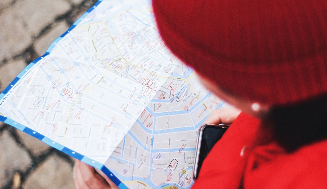 Vrouw gekleed in het rood kijkt op stadsplattegrond