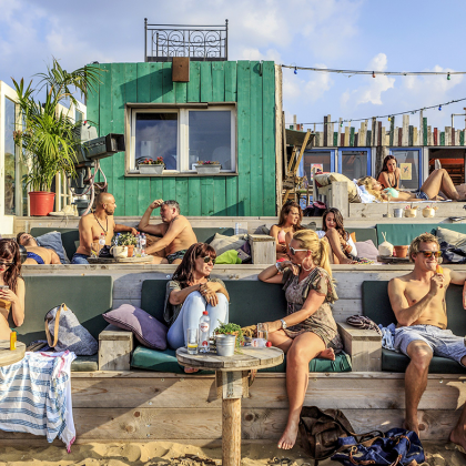 Mensen ontspannen bij Beachclub 'Indigo' in Scheveningen