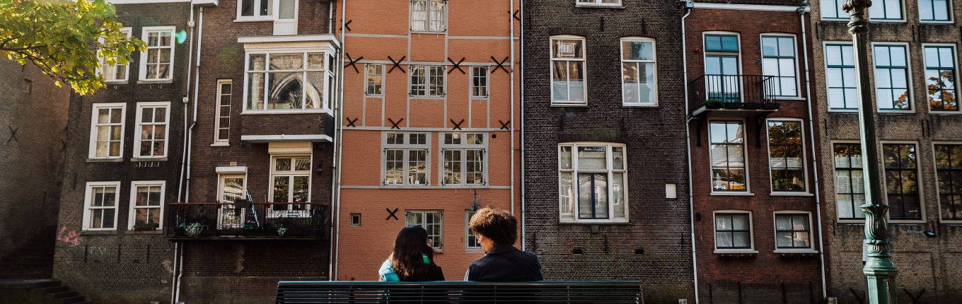 Bezoekers zitten op een bankje in de Grote kerksbuurt te Dordrecht