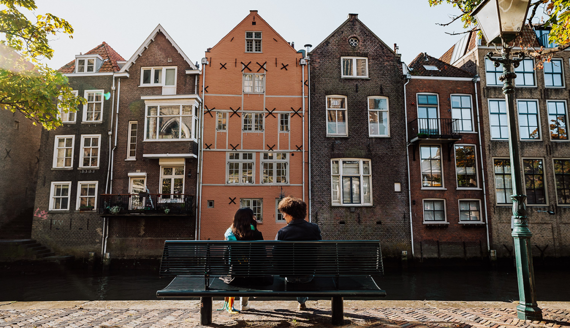 Bezoekers zitten op een bankje in de Grote kerksbuurt te Dordrecht