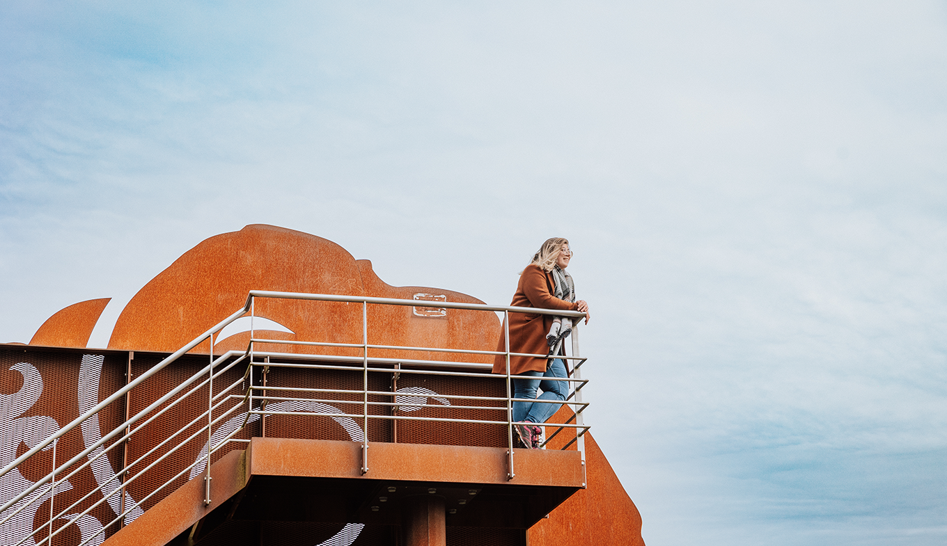 Vrouw kijkt over natuur vanuit uitkijktoren