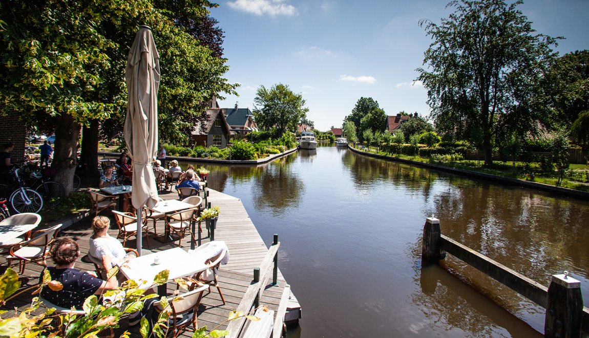 Terras aan het water in de zon. Varen met de boot Weeribben-Wieden