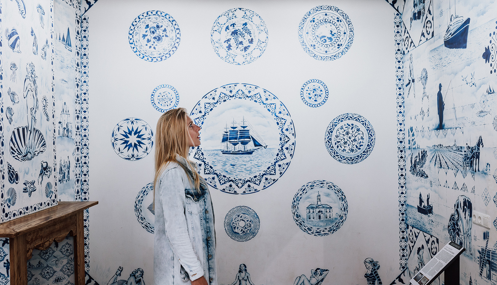 Vrouw bekijkt Delftse Blauwe wand in Zuiderzeemuseum