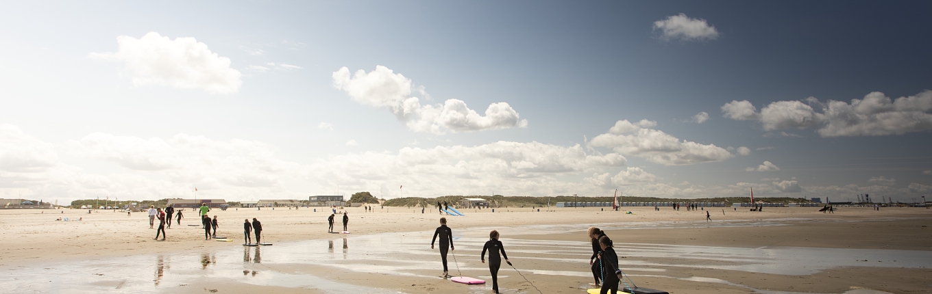 Kinderen lopen uit zee met hun bodyboards op het strand van Hoek van Holland