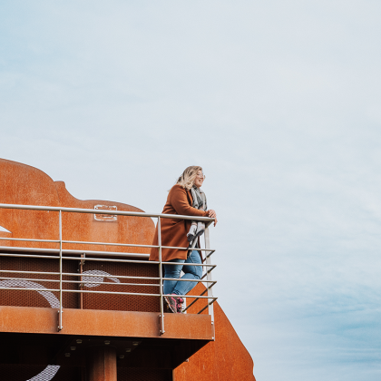 Vrouw kijkt over natuur vanuit uitkijktoren