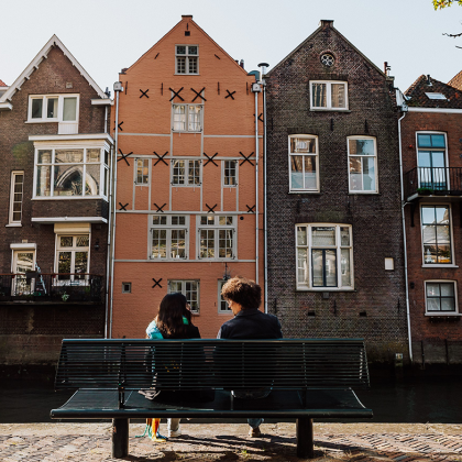 Bezoekers zitten op een bankje in de Grote kerksbuurt te Dordrecht
