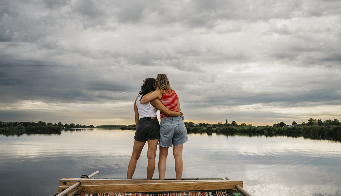 Vriendinnen kijken samen over het water uit in Waterland Vriendinnen kijken samen over het water uit in Waterland