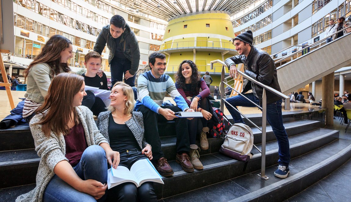 Studenten op de trap in het Atrium van de Haagse Hogeschool