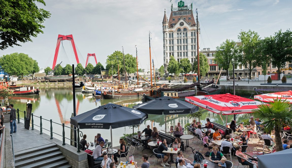 Terras aan de Oude Haven Rotterdam. Achtergrond Het Witte Huis en de rode Willemsbrug